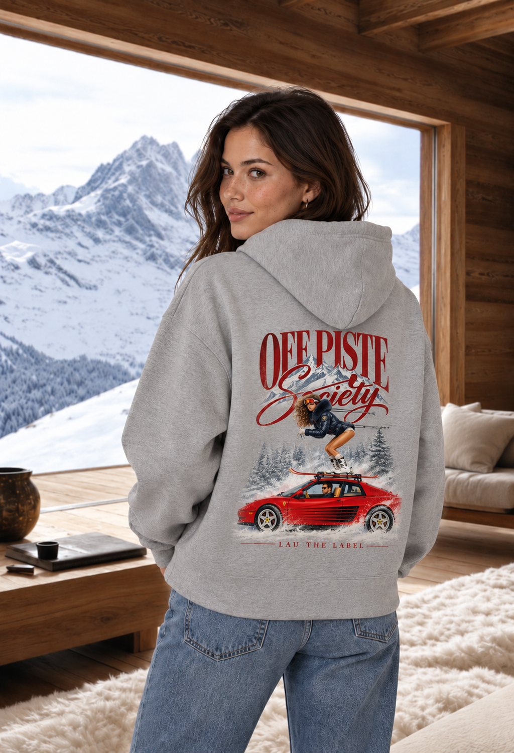 OFF PISTE SOCIETY HOODIE in Heather Grey, achterkant met rugprint van skiester op rode sportwagen, in een chalet met bergzicht